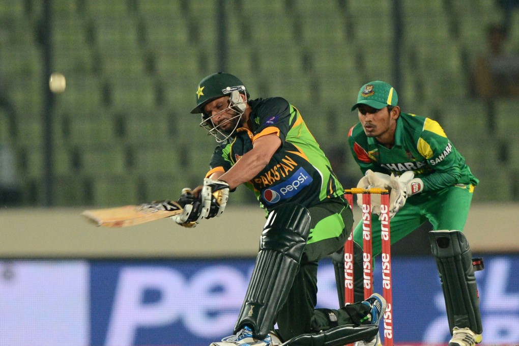 Shahid Afridi plays a shot as Bangladesh wicketkeeper Anamul Haque looks on. Photo: AFP