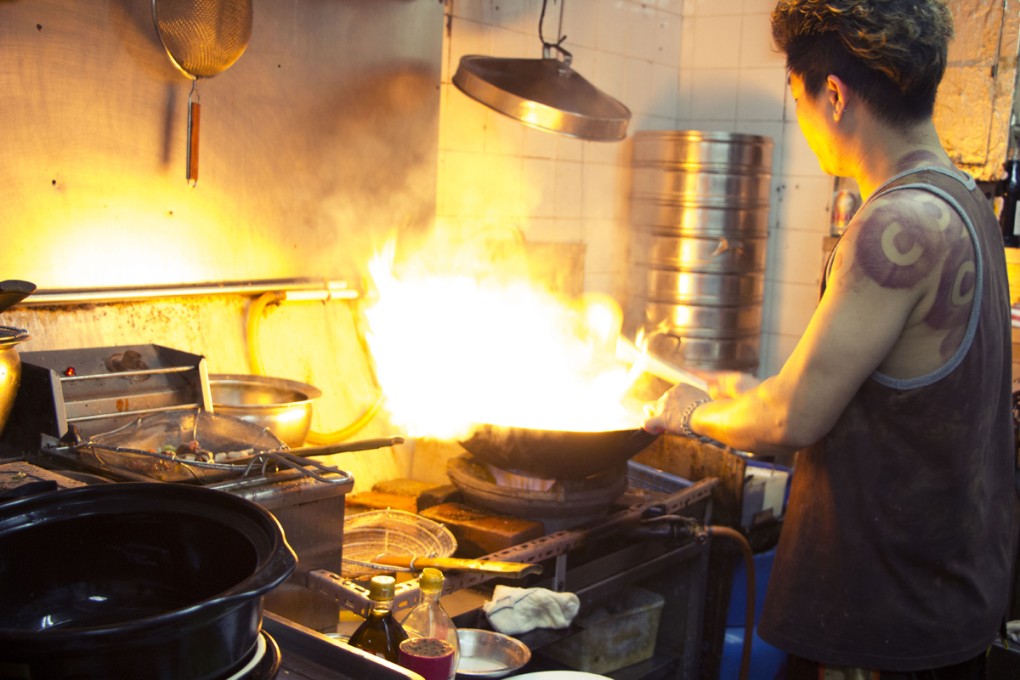 A cook fires up the wok at Tou Yuen Delicacies. Photos: Jade Deakin