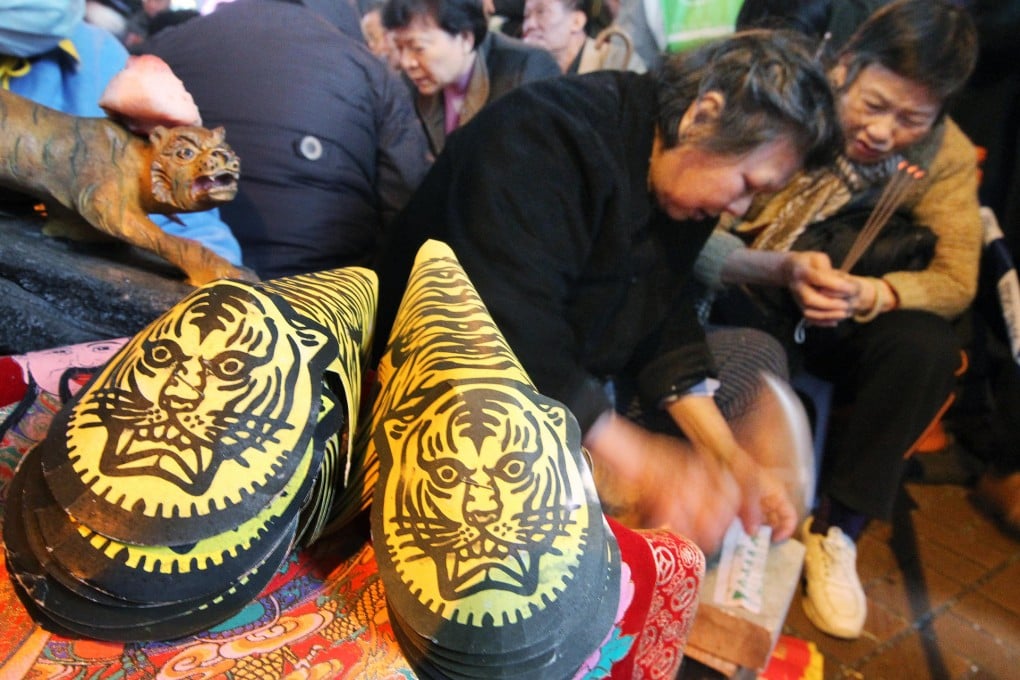 A woman pounds at a paper effigy with a shoe during the Ching che festival under the Canal Road West flyover. Photo: Edward Wong