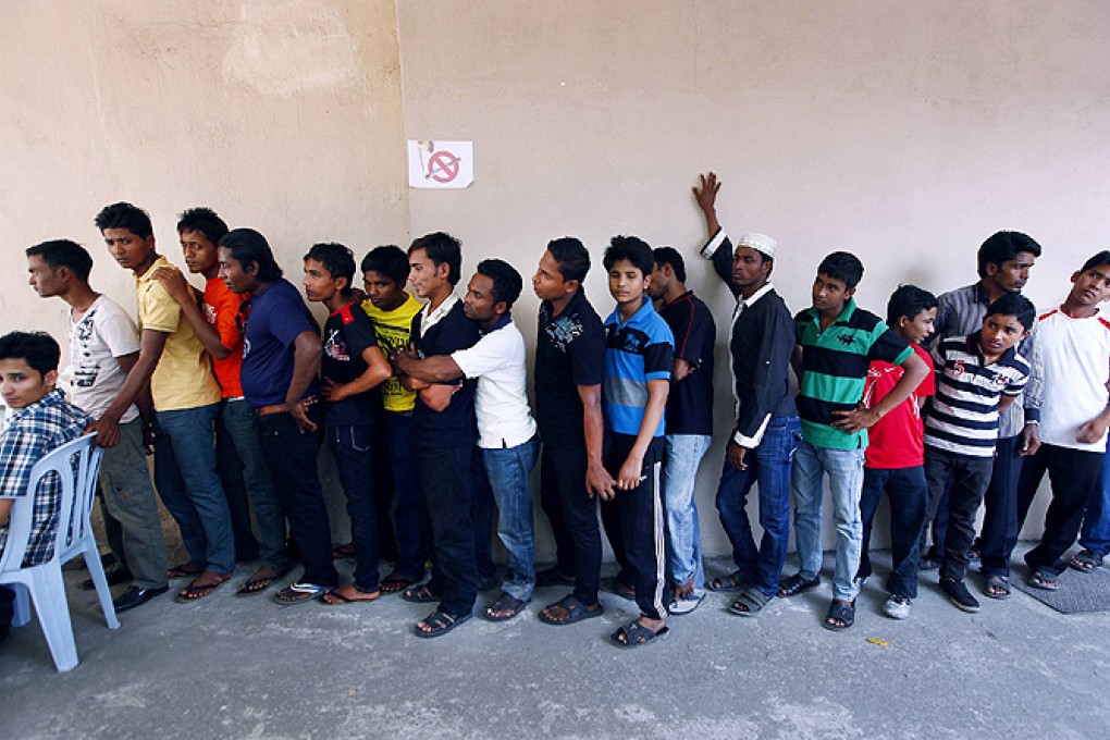 Rohingya men stand in a line at a centre to register for a temporary card issued by UNHCR in Kuala Lumpur. Photo: Reuters