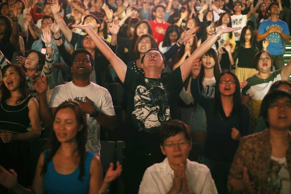 Worshippers at a City Harvest Church service in Singapore last weekend. The city state is becoming a hub for evangelical Christianity, with such churches establishing branches around the world. Photo: Reuters