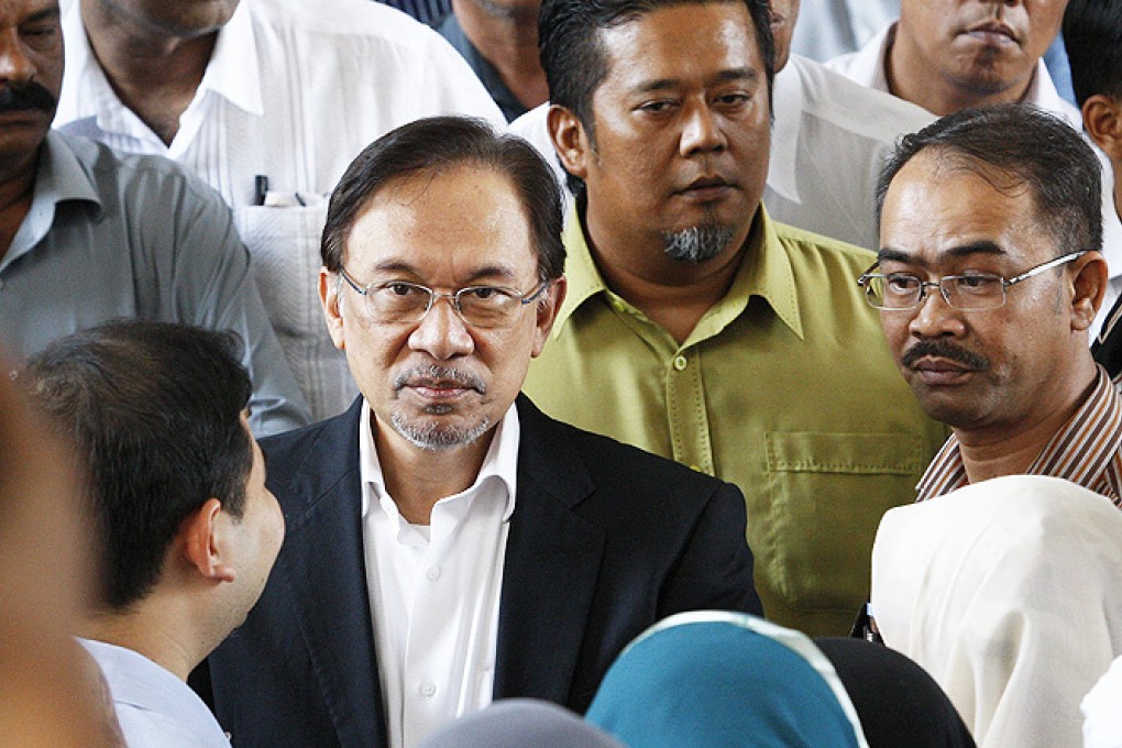 Malaysian Opposition leader Anwar Ibrahim (centre) talks with his supporters in Putrajaya, outside Kuala Lumpur, Malaysia, on Friday. Photo: EPA
