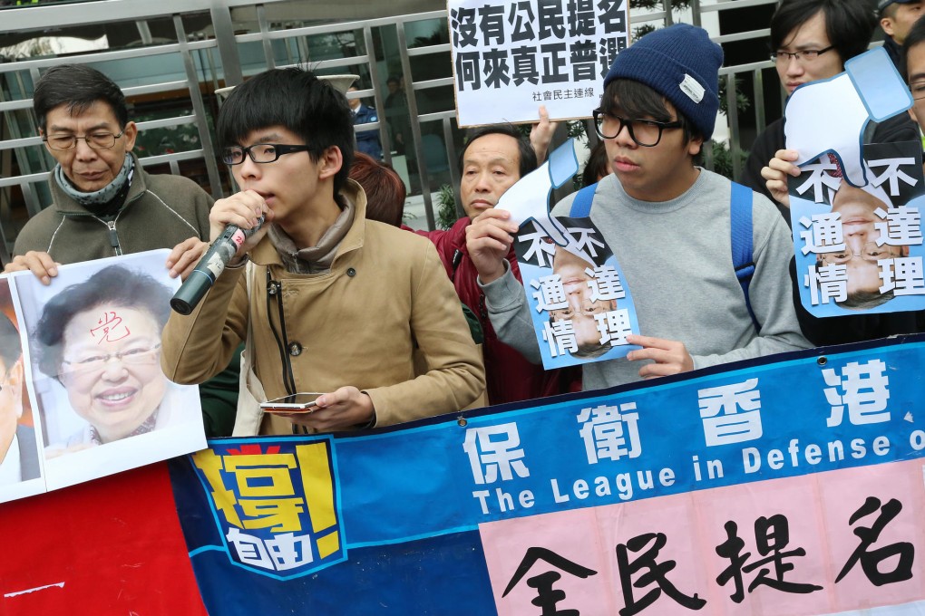 Scholarism convenor Joshua Wong (with microphone) and protestors rally outside the liaison office yesterday. Photo: David Wong
