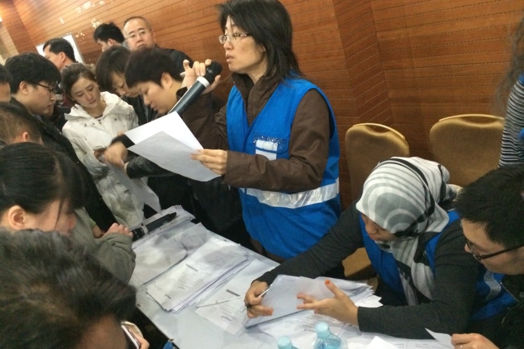 A member of a special assistance team of Malaysian Airlines speaks to the relatives of those on board the missing flight in Beijing. Photo: Xinhua