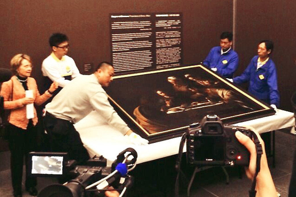 Workers lift up Caravaggio's Supper at Emmaus at the Asia Society Hong Kong. Photo: Vivienne Chow