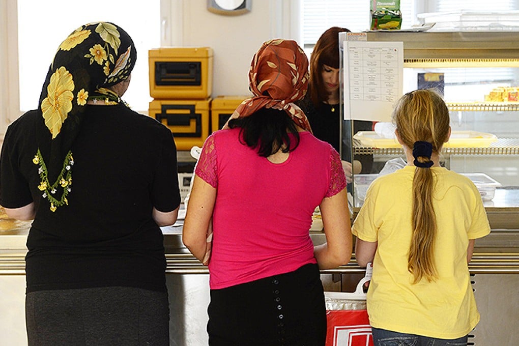Asylum seekers queue for food at a shelter in Berlin. Photo: AFP