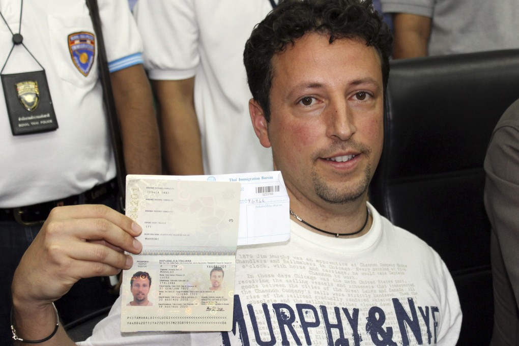 Italian Luigi Maraldi, whose stolen passport was used by a passenger boarding the missing Malaysia airlines flight 370, shows his passport as he reports himself to Thai police at Phuket police station in Thailand. Photo: AP