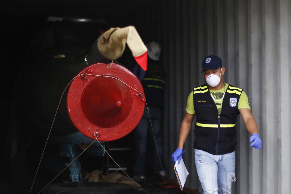 A forensic worker carries out investigations in a container holding aircraft seized from a North Korean ship in Colon, Panama. Photo: Reuters