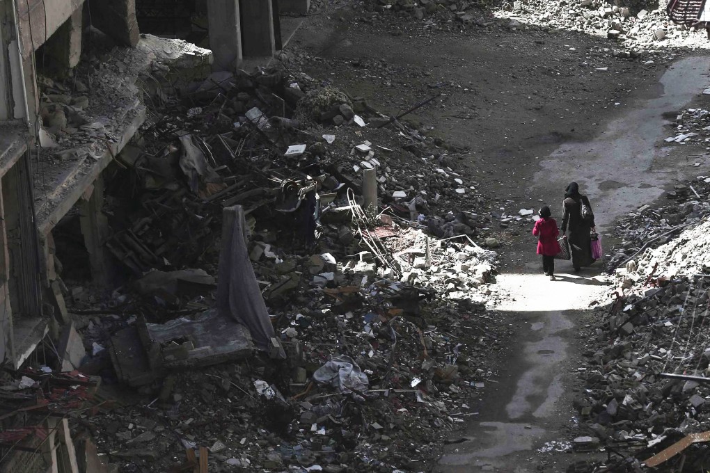 Residents walk past rubble and damaged buildings in Damascus. There are reports of a new front being opened in the civil war. Photo: Reuters