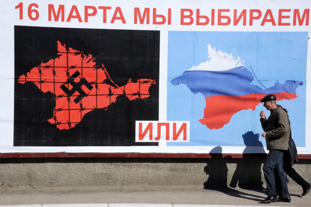 A man walks past a poster setting out a stark Crimean referendum choice in Sevastopol. Photo: AFP