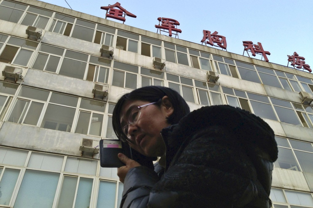 Wang Yu, the lawyer of human right activist Cao Shunli, talked on the phone in front of a hospital building where Cao was hospitalized in Beijing. Photo: Reuters