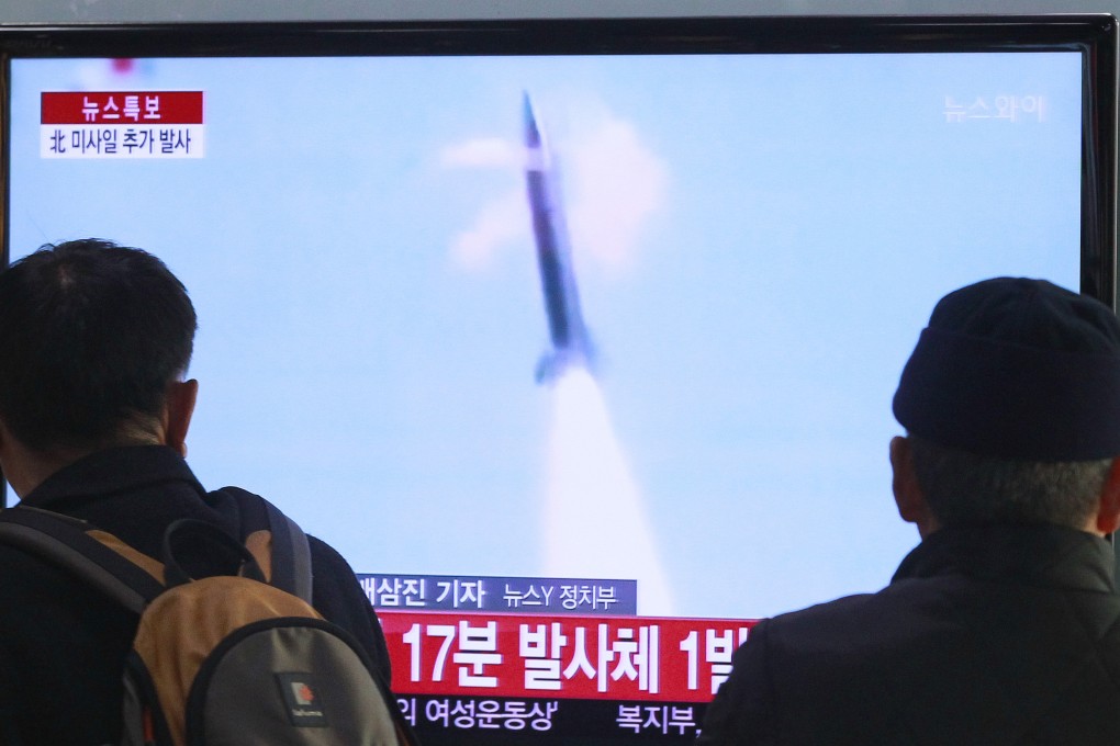 People watch TV reporting North Korea's missile test. Photo: AP