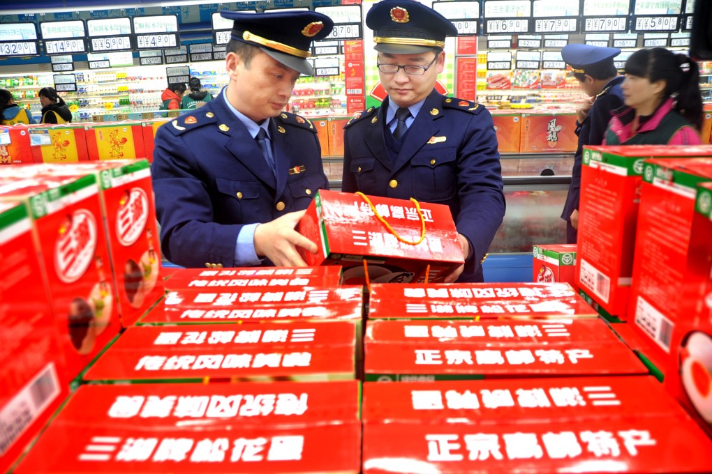 Staff members of the commerce and industry bureau check the quality information of food in a supermarket ahead of the World Consumer Rights Day in Lianyungang, east China's Jiangsu Province. Photo: Xinhua