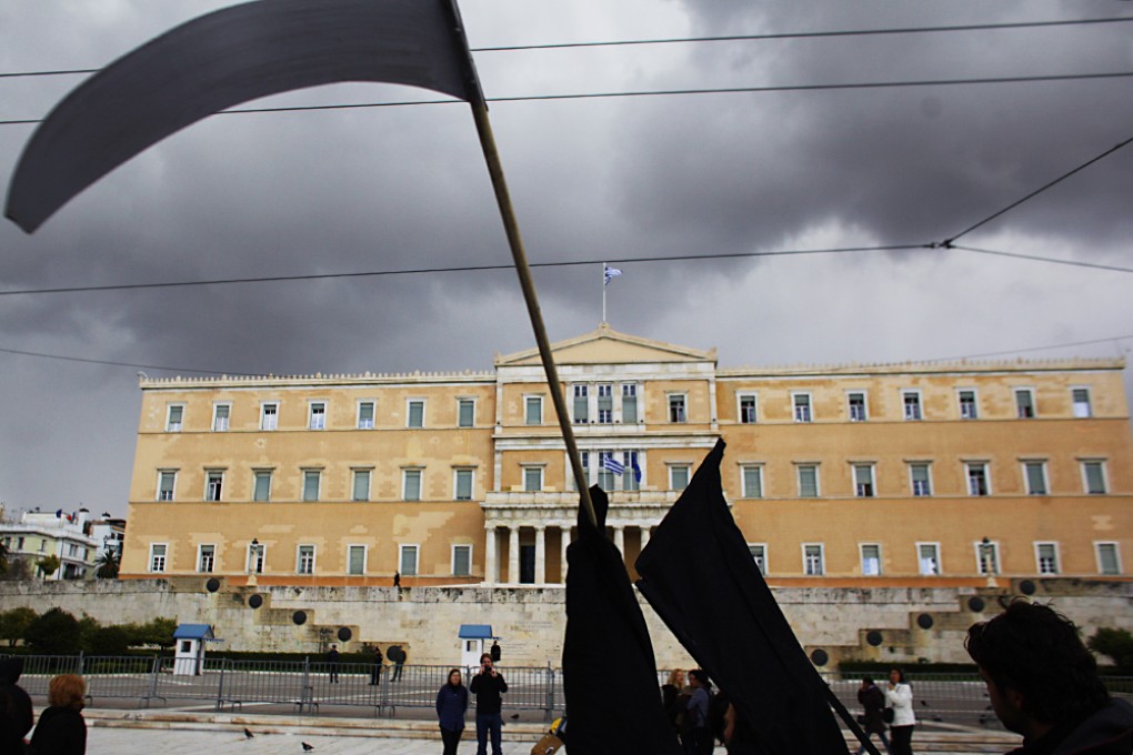 Protesters carry a scythe during a demonstration by tax accountants against a new tax law outside the Greek Parliament in central Athens. Photo: AP