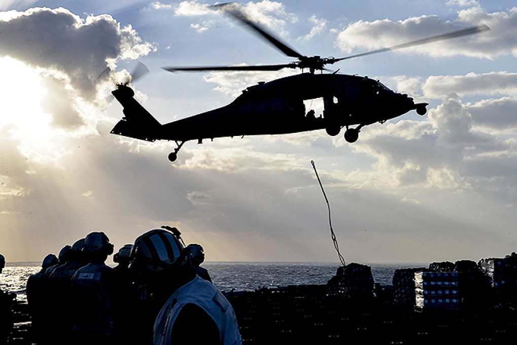 A US Sea Hawk helicopter drops supplies to amphibious assault ship USS Bataan. US Navy Seals took control of a North Korea-flagged tanker at a port in eastern Libya. Photo: AFP