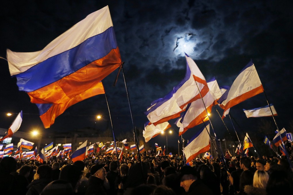 People hold Russian flags as they gather at Lenin Square after the end of the referendum in Simferopol, Crimea, Ukraine, 16 March 2014. Photo: EPA