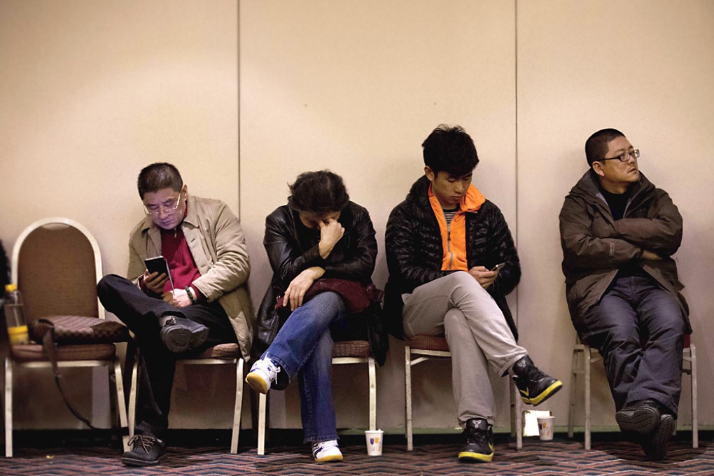 Relatives of Chinese passengers aboard the missing Malaysia Airlines Flight MH370 wait for a news briefing held by the airlines' officials at a hotel ballroom in Beijing Monday. Photo: AP