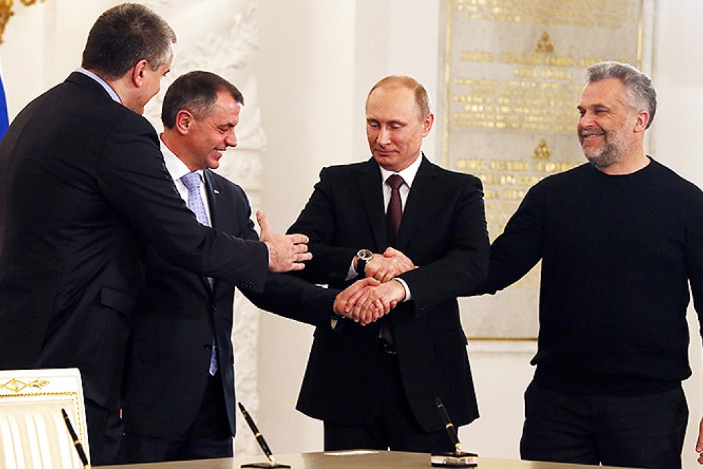 Russian President Vladimir Putin, second right, Speaker of Crimean legislature Vladimir Konstantinov, second left, Crimean Premier Sergei Aksyonov, left, and Sevastopol mayor Alexei Chalyi, right, shake hands after signing a treaty for Crimea to join Russia in the Kremlin in Moscow. Photo: AP