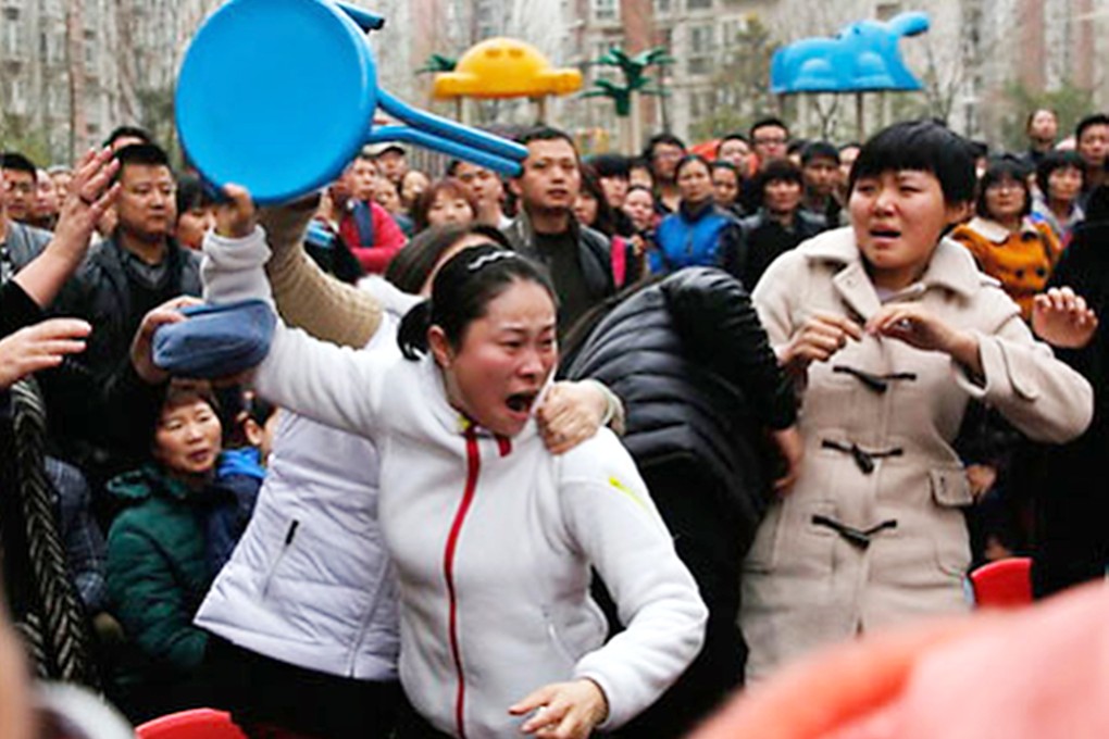 A mother reacts in anger last week during a meeting with officials investigating the drug case at her child's nursery school in Xian. Photo: ChinaFotoPress