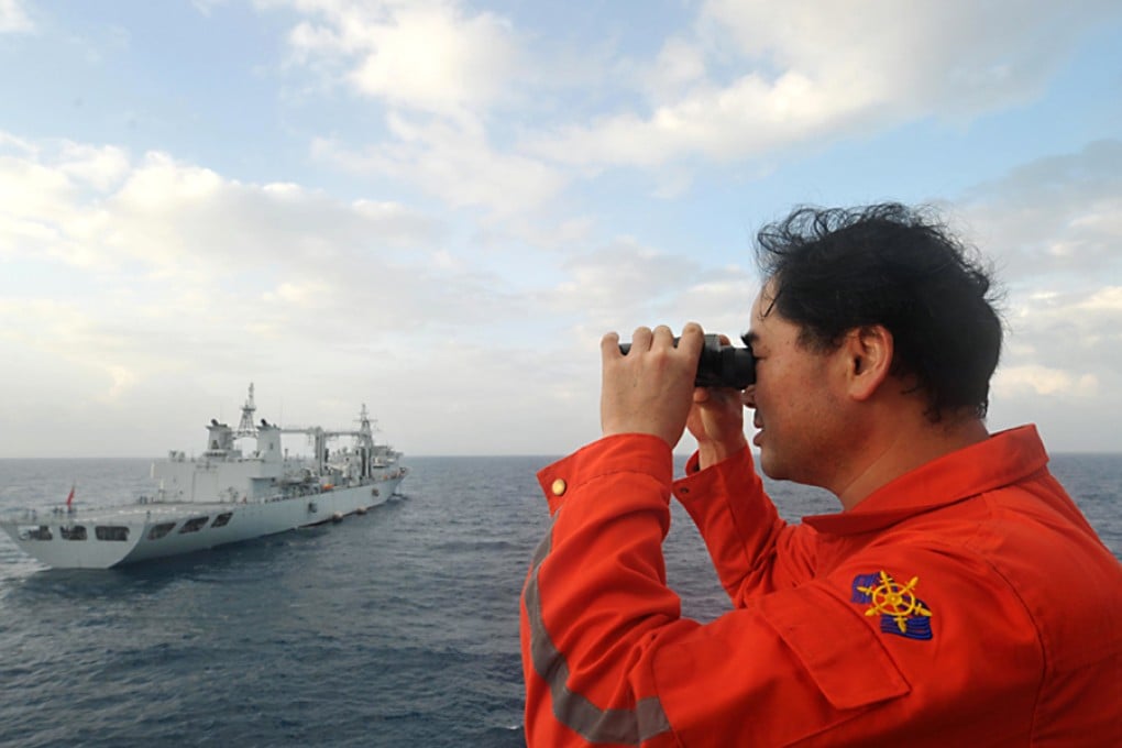 Vice commander of the Chinese rescue vessel "Nanhaijiu 101" Zhang Jianxin watches as the ship approaches the Chinese Navy's Qiandaohu supply ship, as both of them head toward Singapore to join in the search for missing Malaysia Airlines flight MH370, March 18, 2014. Photo: Xinhua