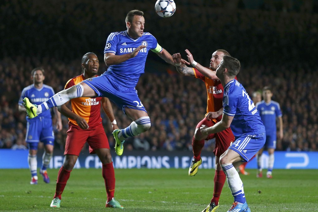 Chelsea's John Terry heads the ball clear as Galatasaray's former Chelsea striker, Didier Drogba (left), looks on. Photo: Reuters