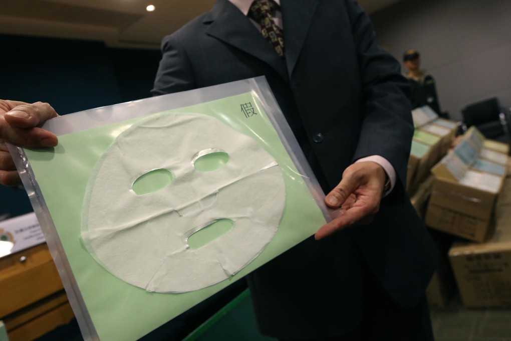 A customs officer displays a sample of the counterfeit My Beauty Diary cosmetic masks seized in the raid. Photo: David Wong