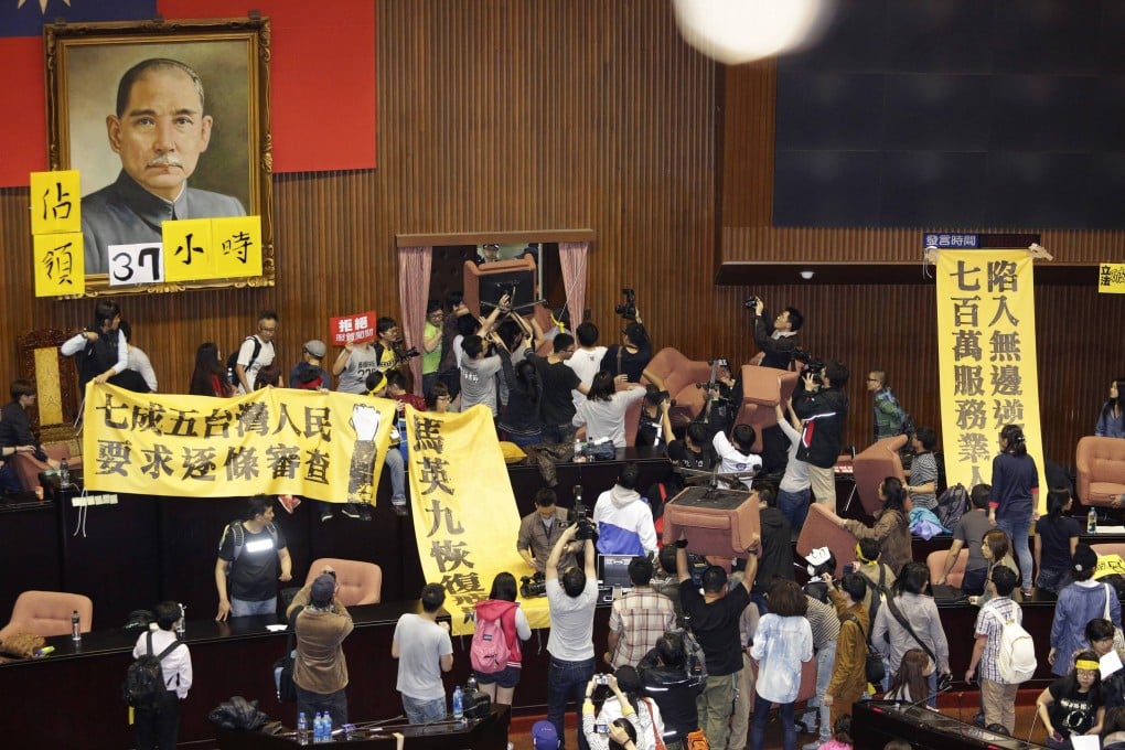 Students and protesters hold banners and chairs inside Taiwan's legislature in Taipei. Photo: Reuters