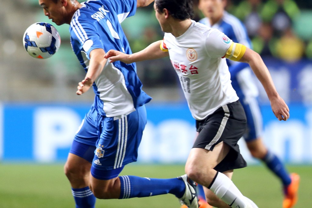 Ulsan Hyundai forward Kim Shin-Wook (left) vies for the ball with Guizhou Renhe defender Sun Jihai. Photo: AFP