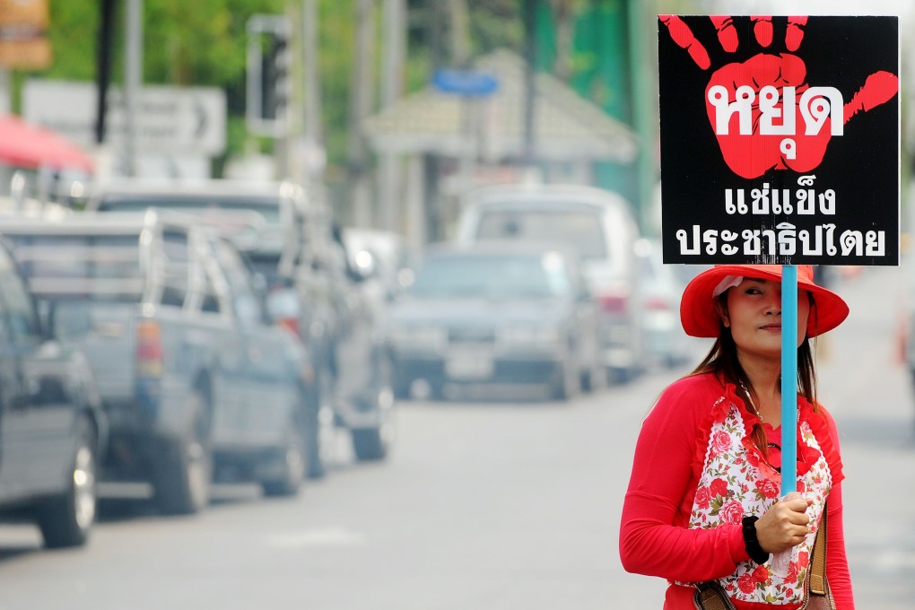 A "Red Shirts" supporter of Thai Prime Minister Yingluck Shinawatra holds a placard during a gathering in Bangkok on February 27, 2014. Photo: AFP