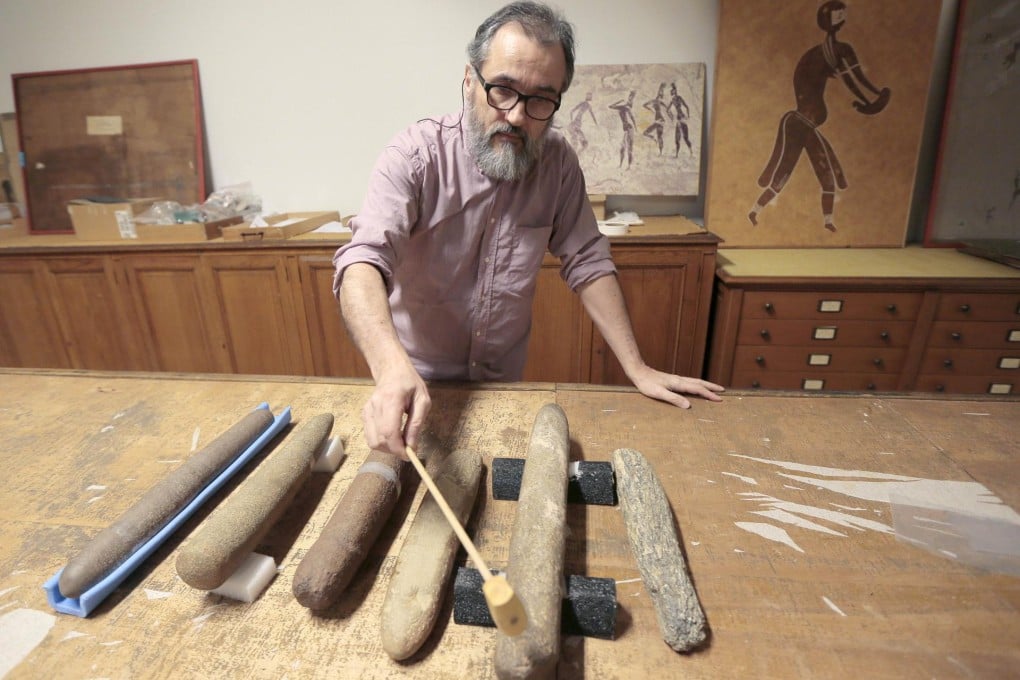 Paleomusicologist Erik Gonthier plays the lithophone. Photo: AFP