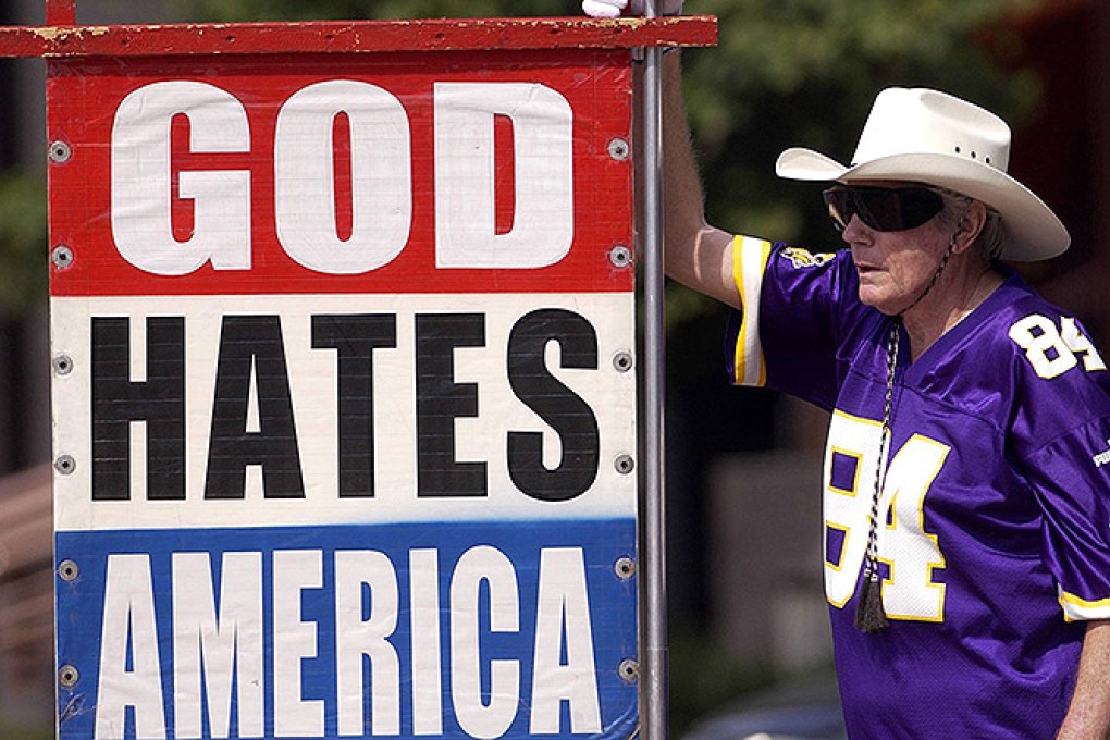 Fred Phelps displays one of his many infamous protest signs. Photo: AP