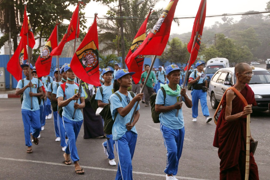Buddhist monk and activists holding flags march to protest against Myitsone dam project. Photo: AP