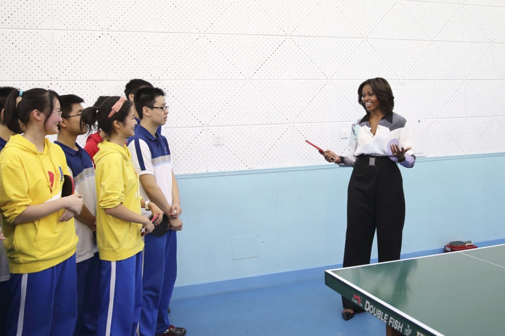 US First Lady Michelle Obama talks with students who practise table tennis while visiting the Second High School in Beijing. Photo: Xinhua