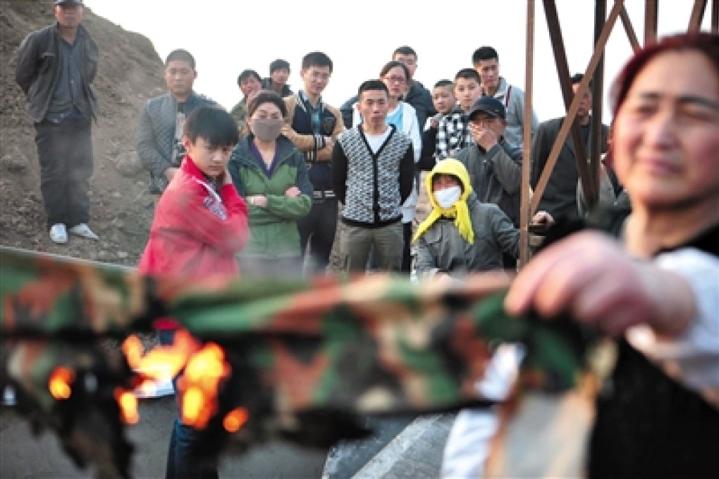 Villagers gather around the debris of the tent that was set on fire on March 21. Photo: Weibo