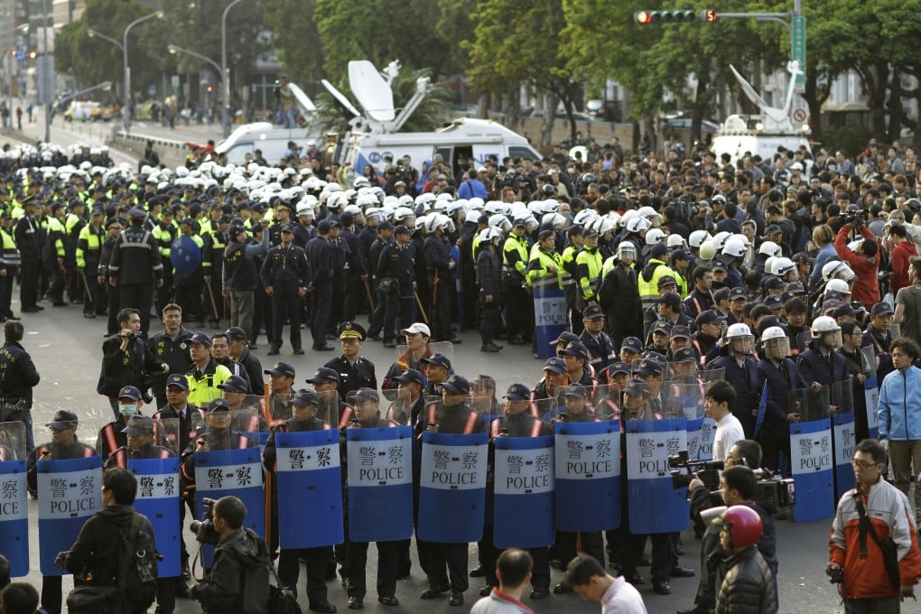 Hundreds of police in riot gear clear the streets surrounding the government Cabinet buildings occupied by student protesters in Taipei, Taiwan. Photo: AP