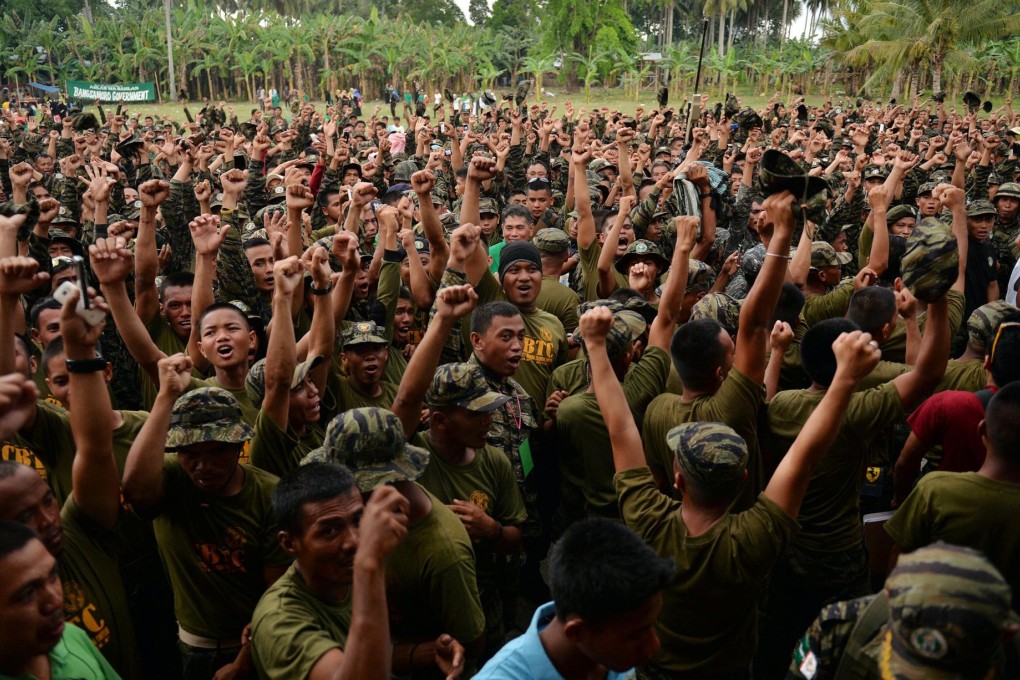 Moro Islamic Liberation Front rebels in Mindanao cheer after hearing the peace agreement had been signed. Photo: AFP