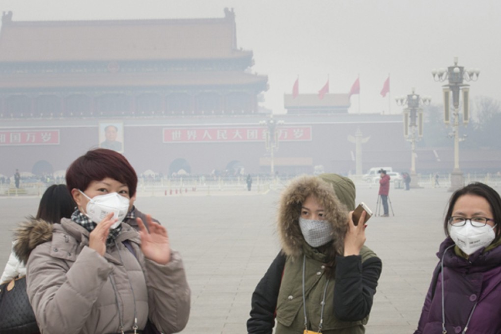 Tourists wearing face masks to protect themselves from thick smog outisde the Great Hall of the People in Beijing earlier this month. Photo: EPA