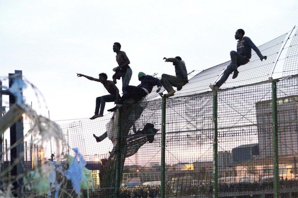 Sub-Saharan immigrants attempt to jump the fence into Melilla in north Africa