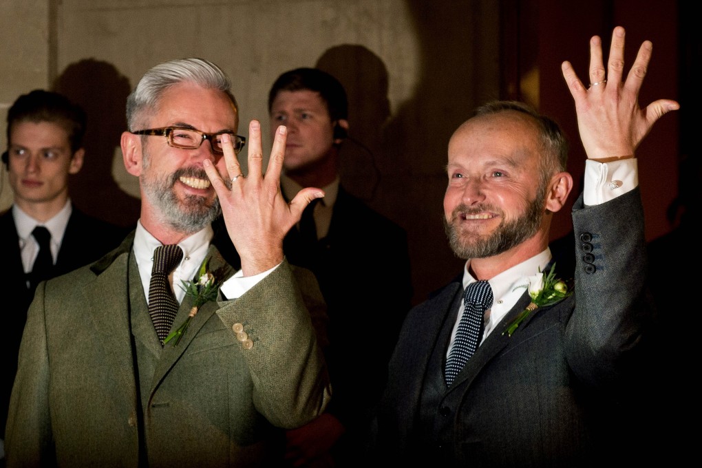 Andrew Wale (L) and Neil Allard show their wedding rings following their wedding at the Royal Pavillion in Brighton early on March 29, 2014. Photo: AFP