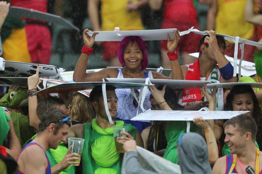 Spectators in the South Stand make rain hats out of their costumes as thunderstorms lash the Hong Kong Sevens. Photo: KY Cheng/SCMP