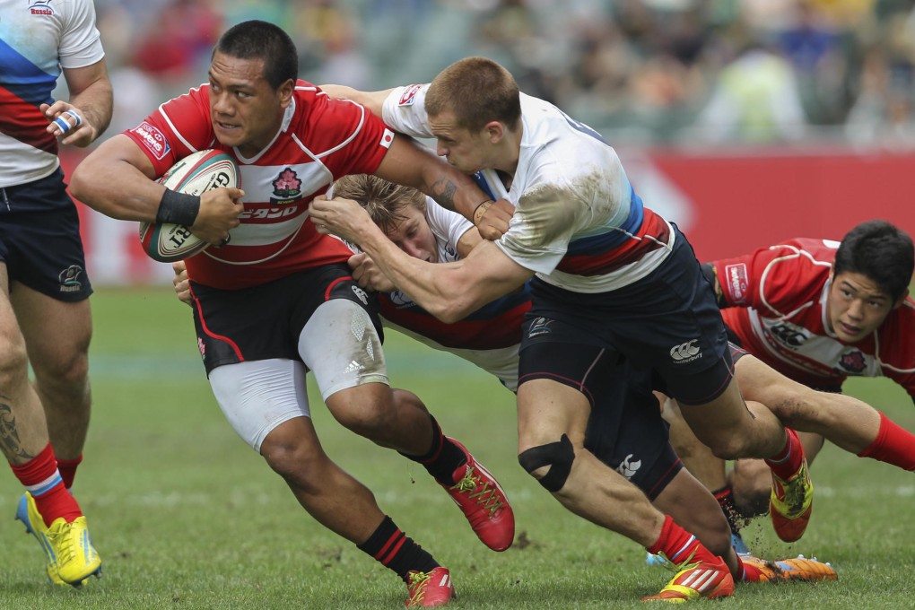 Japan's Lomano Lemeki brushes off Russian defenders in their World Series qualifier on the final day. Photo: Dickson Lee