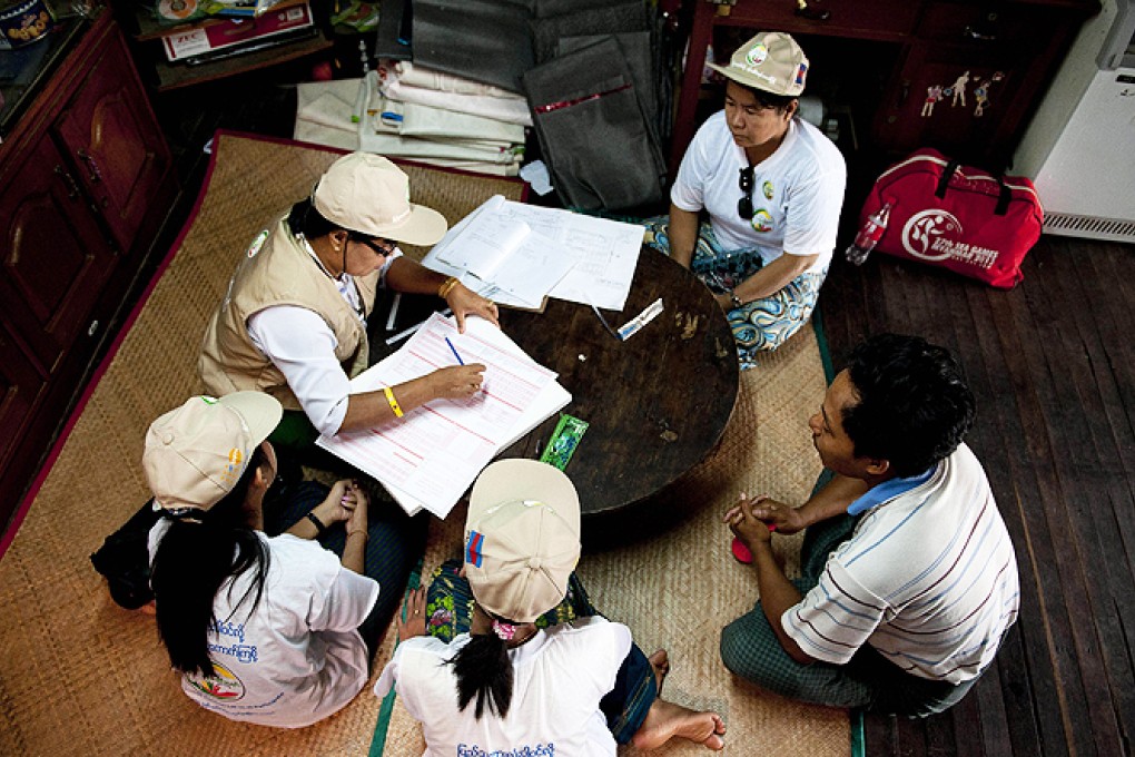 Workers collect census data from a family in Yangon on Sunday. Photo: AP