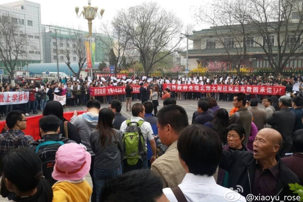 Crowds of residents hold up banners and shout slogans outside a local government office in Changping District, Beijing on March 31, 2014. Photo: Weibo user