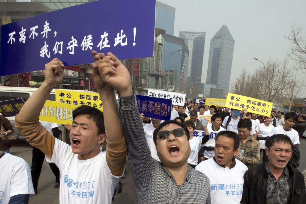 Chinese relatives of passengers on board the missing Malaysia Airlines flight MH370 shout in protest as they march towards the Malaysia embassy in Beijing. Photo: AP