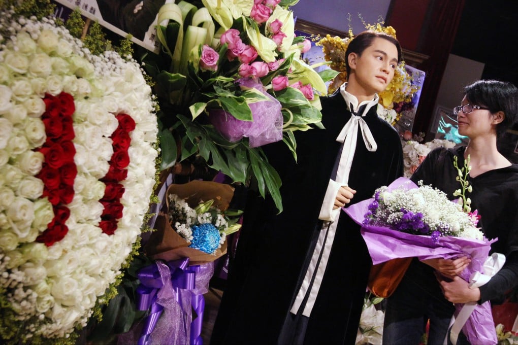 A fan adds to wreaths beside the star's wax figure. Photo: Nora Tam