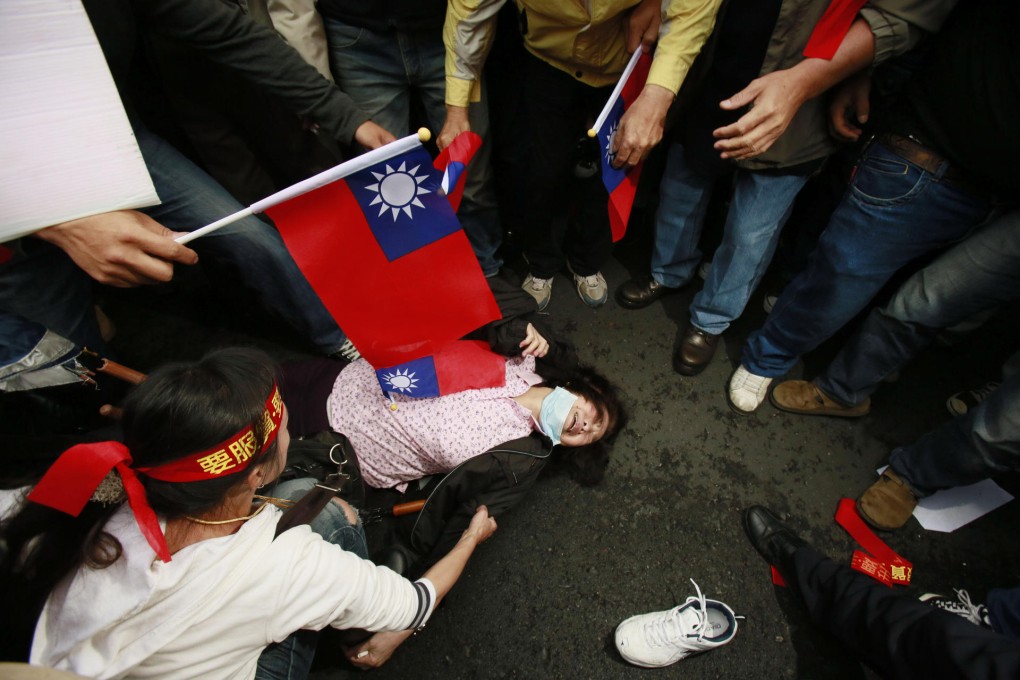 A supporter of closer cross-strait relations falls during a raucous rally near the Taiwanese legislature in Taipei yesterday. Photo: AP