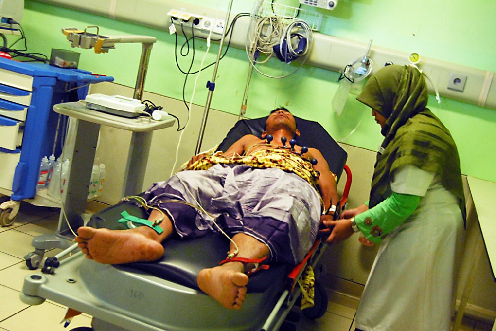A seriously wounded member of the Aceh Party in hospital in Banda Aceh after two men on a motorcycle opened fire on a small van decorated with pictures of election candidates from the Aceh Party. Photo: AFP