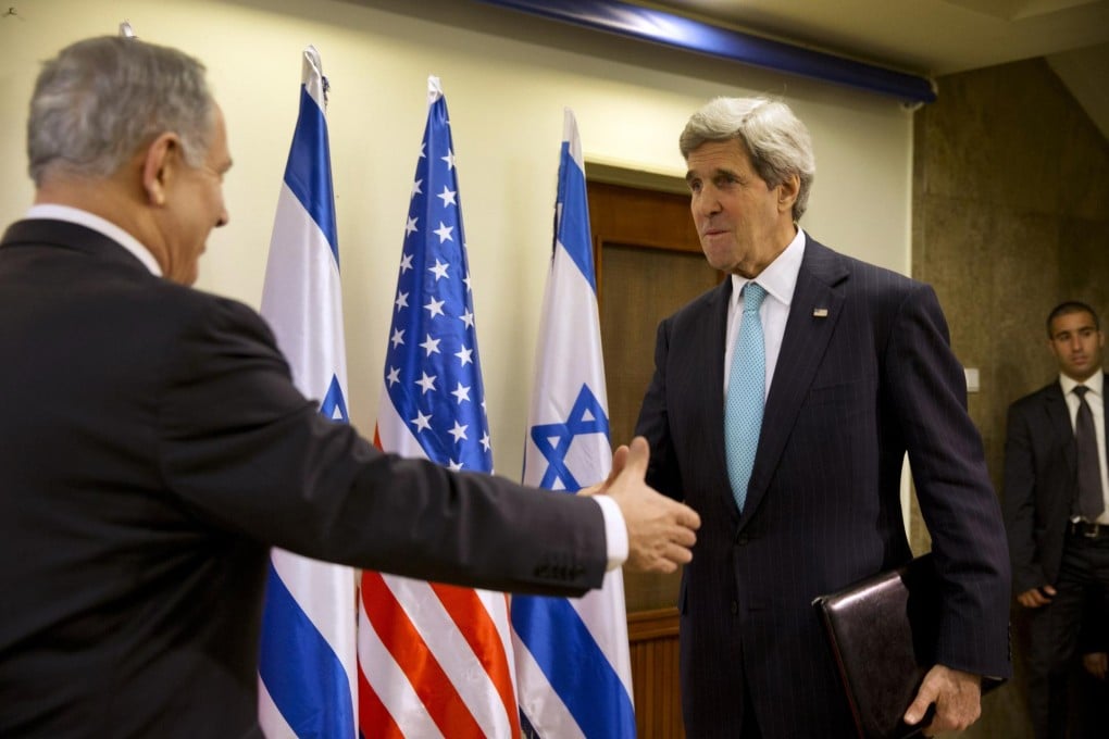 Benjamin Netanyahu offers a hand to John Kerry in Jerusalem. The peace talks are snagged over several issues. Photo: Reuters