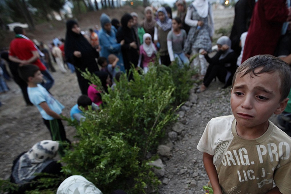 A Syrian refugee boy cries as he attends the funeral of five Free Syrian Army fighter. Photo: Reuters