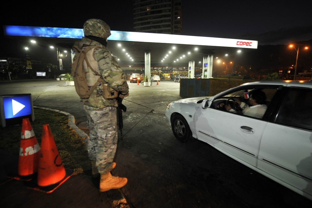 A Chilean Army soldier guards a gas station in Iquique. Photo: AFP